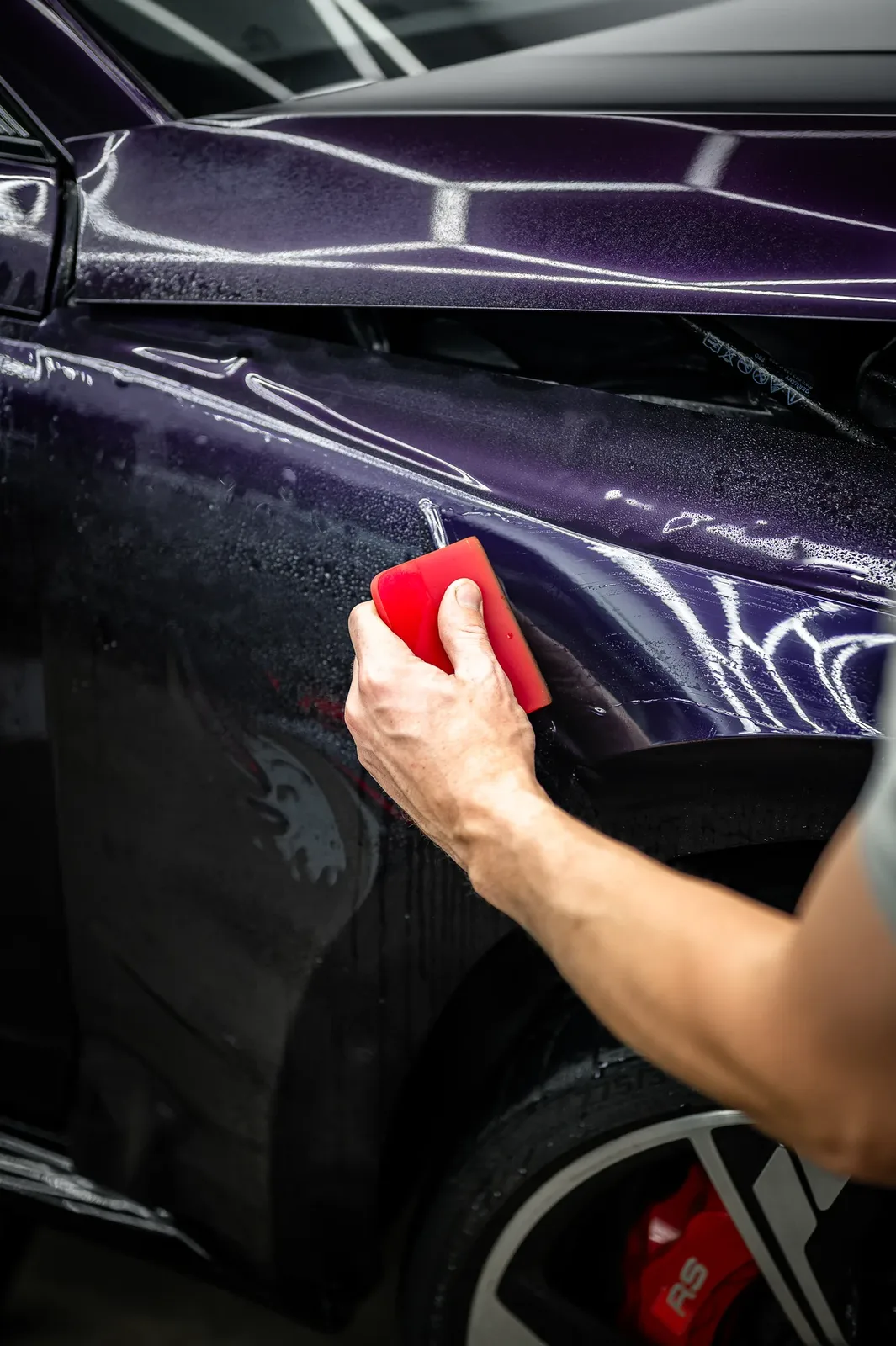 Detailing a purple colour PPF panel with a squeegee at Tiger Tint & Wrap Christchurch