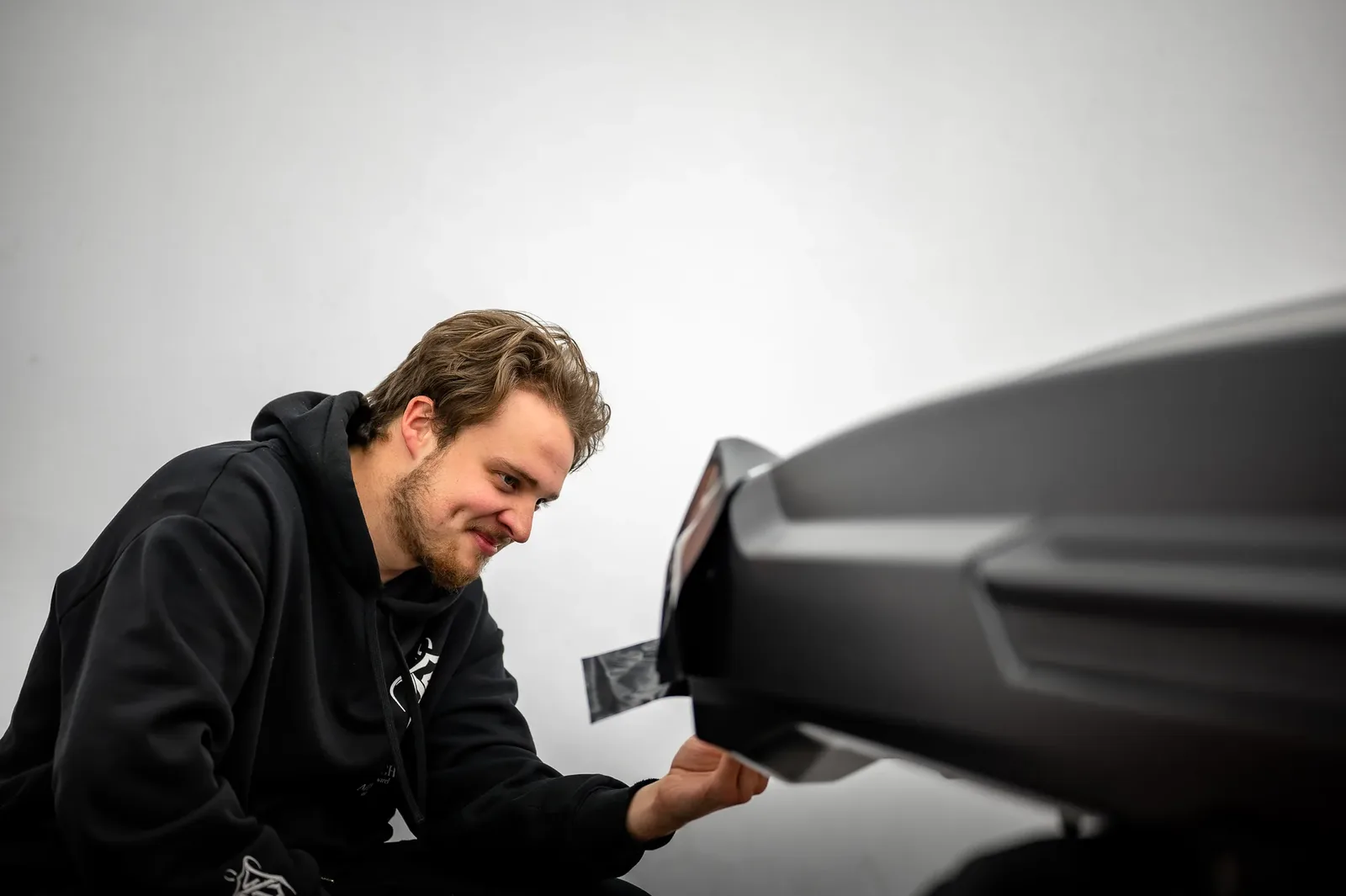 Tiger Tint & Wrap installer squeegeeing freshly applied window tint in the Christchurch workshop
